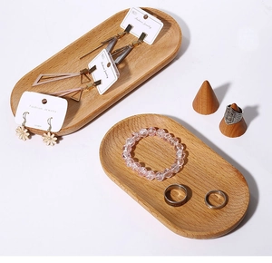 Close-up of oval wooden jewelry trays and conical ring stands with fine wood grain