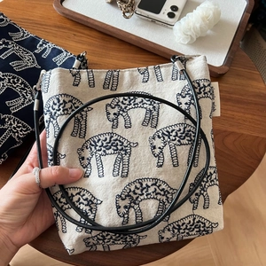 Detailed embroidery of navy sheep pattern on cream cotton linen crossbody phone bag