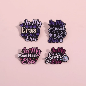 Detail view of 4-piece enamel pins set with Eras Era and Swiftie Era engraved text