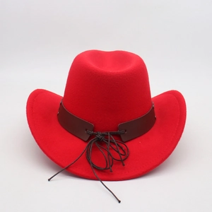 Detail of bright red felt cowboy hat with dark brown leather band and curved brim