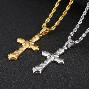 Close-up of hip hop cross pendants in gold and silver with twisted rope chains
