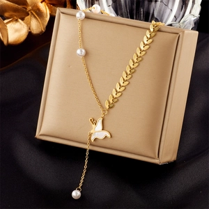 Golden snake bone chain with leaf links pearl accents and butterfly pendant on luxury box