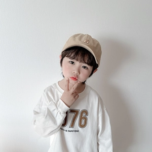Gros plan d'un enfant portant une casquette kaki et un t-shirt blanc imprimé 976 assorti