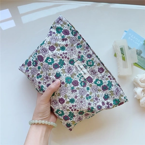 Close-up of floral cotton makeup bag with simple wish label and purple flower patterns