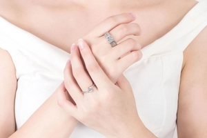 Close-up of geometric pattern couple rings with square cut diamonds on fingers