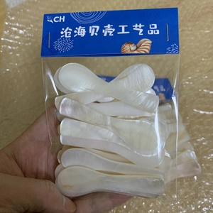 Bulk white seashell spoons for caviar or facial masks packed in a clear plastic bag