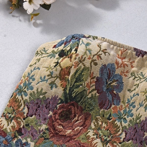 Detail eines Vintage-Jacquard-Stoffs mit bunten Stickereien und gewebter Textur