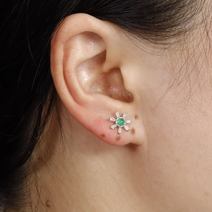 Floral stainless steel stud earring with green gemstone and white zircon on ear lobe
