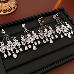 Macro view of silver floral tassel earrings with sparkling zircon crystals on black tray