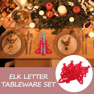 Detail of red Christmas tree felt cutlery holder with elk and star patterns on festive table
