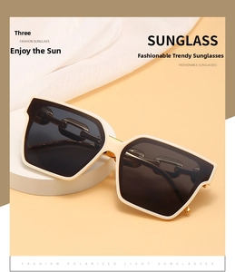 Detail of luxury cream square frame sunglasses with golden chain metal hinge accents