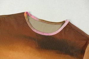 Close-up of the round neckline on a gradient knit dress showing fine mesh texture