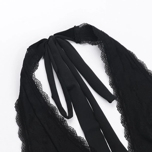 Close-up of black lace halter top showing deep V-neckline and intricate strap detailing