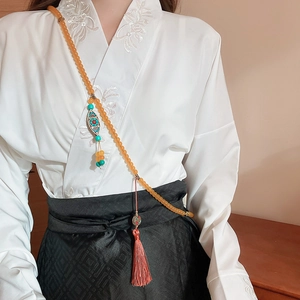 Detailed view of an ethnic crystal beaded necklace with silk tassels on Hanfu clothing