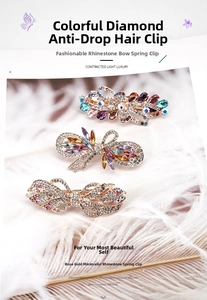 Détail de trois barrettes en cristal avec strass disposées sur un fond de plumes douces