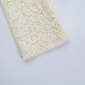 Detail der eleganten cremefarbenen Spitzenmanschette mit aufwendigen Blumenmustern