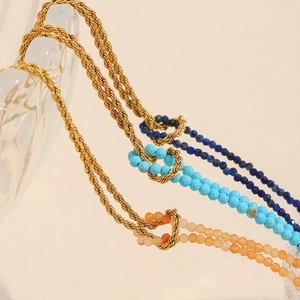 Detail of twisted 18K gold plated chain bracelets with blue and orange natural stones