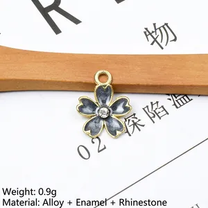 Macro view of a 1.4x1.7cm alloy cherry blossom pendant with blue enamel and rhinestone