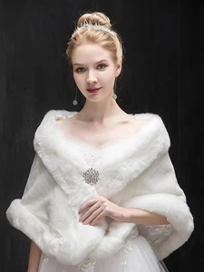Detailed view of white faux fur bridal shawl with sparkling rhinestone brooch fastener