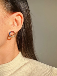 Close-up of a model wearing petite rainbow cubic zirconia circle earrings in a silver setting