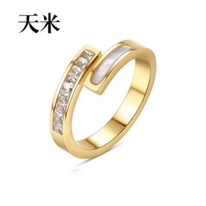Detail eines vergoldeten offenen Rings mit Zirkonia im Quadratschliff und Muscheleinlage