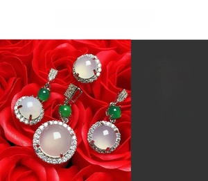 Detailed view of translucent lavender chalcedony jewelry set nestled in red roses