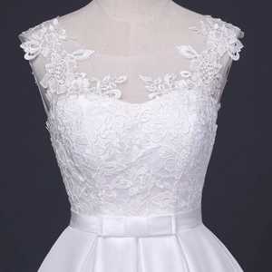 Detail der floralen Spitzenstickerei und Satin-Gürtel mit Schleife am weißen Brautkleid