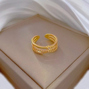Macro shot of gold layered crossover ring with pavé zircon stones on jewelry box