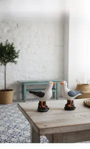 Detailed view of resin seagull sculptures on a wooden table with Mediterranean decor