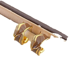 Brown and gold C-shaped enamel earrings with wave design on a neutral background