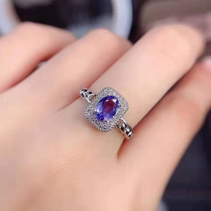 Elegant lavender purple oval gemstone ring with diamond halo and chain band on hand