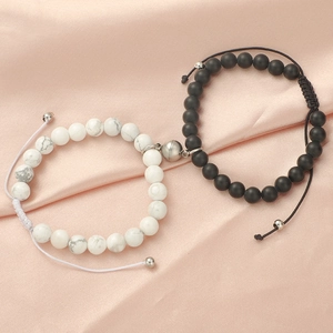 Detail of magnetic couple bracelets with matte onyx and white turquoise beads on pink silk
