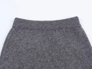Close-up of dark grey jacquard knit skirt featuring a ribbed elastic waistband detail
