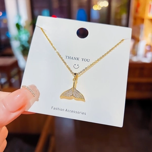 Élégant collier queue de sirène dorée avec pendentif en cristal étincelant sur carte