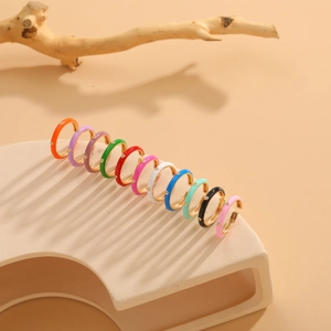 Detailed display of 11 pairs of golden enamel hoop earrings in assorted vibrant colors