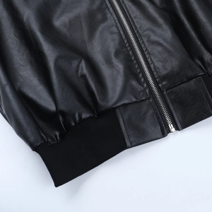 Detail of vintage black leather jacket showing silver zipper and ribbed elastic hemline