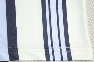 Détail de couture à double ligne sur tissu texturé à rayures verticales bicolores