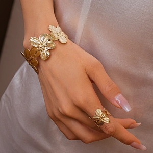 Detail of gold metal flower cuff bracelet and ring set with fine brushed petal texture