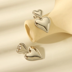 Macro shot of silver heart earrings with double overlapping design and polished finish