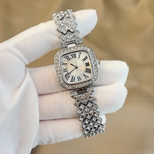 Detailed macro of a silver square quartz watch with crystal-encrusted band and Roman numerals