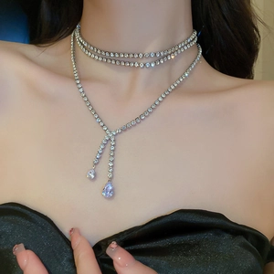 Nahaufnahme von silberner Choker-Kette und Y-Halskette mit funkelnden Strass-Tropfen