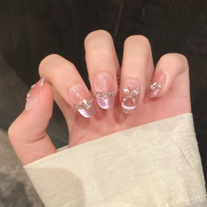 Pink cat eye gradient press-on nails with rhinestone bow and almond shape design