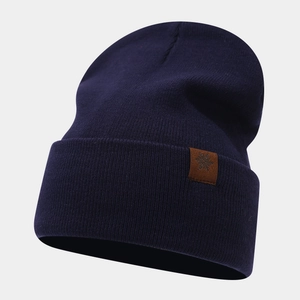 Detail of the dark blue knitted beanie with a brown snowflake leather patch and fine texture