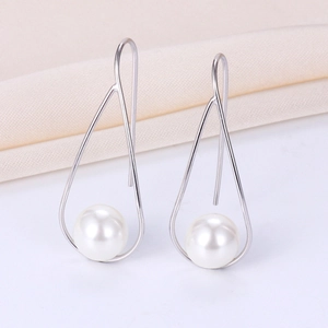 Detail of silver geometric triangle pearl drop earrings with glossy white pearls