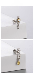Macro detail of silver titanium steel earrings featuring yellow opal and zircon stones