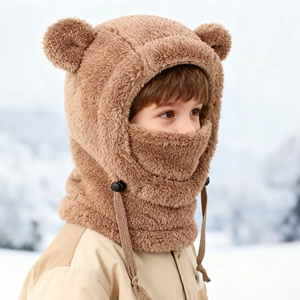 Détail d'un bonnet ours en peluche marron avec masque intégré pour enfant dans la neige