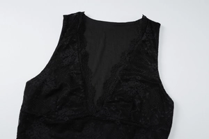 Detail view of V-neck floral lace pattern on a stylish black sleeveless dress