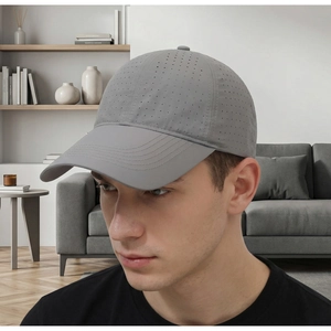 Detail showing laser-cut perforations and breathable mesh on a gray polyester baseball cap