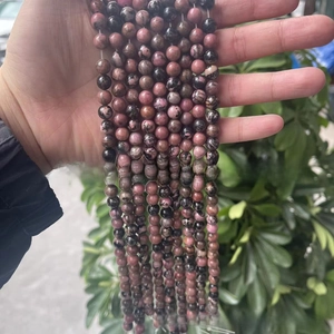 Gros plan de perles en pierre de rhodonite naturelle rose et noire pour bijoux