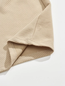 Close-up of beige knit fabric texture and reinforced double-stitched hem on men jacket